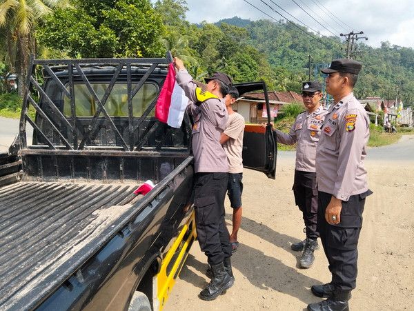 Bhabinkamtibmas Polsek Tanjung Raya Bagikan dan Pasang Bendera Merah Putih di Desa Bangun Jaya
